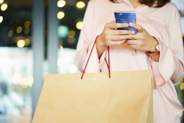 cerrar mujer susing smartphone sosteniendo bolsas frente centro comercial 42708 220 - inova3 - Marketing digital desde ourense